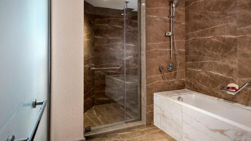 a bathroom with a shower and a bath tub at Crowne Plaza Florya Istanbul by IHG in Istanbul