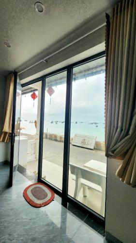a room with a large window with a view of the ocean at La Maison Hòn Sơn in Lai Sơn
