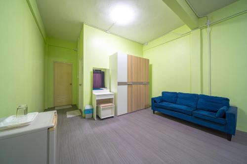 a living room with a blue couch in a room at UrbanNest Hostel in Pattaya