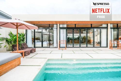 a swimming pool in front of a building at 99 Villa Suite - Modern Bedrooms with Dining Area & Enormous Pool in Kerobokan