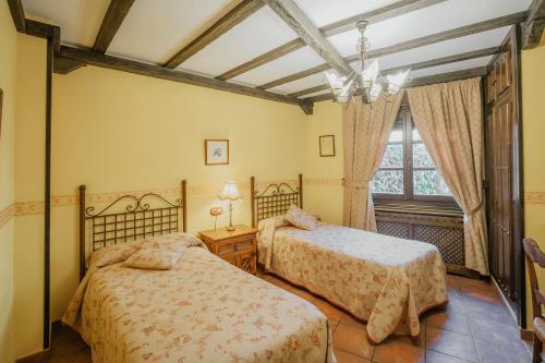 a bedroom with two beds and a window at Villa De Urueña Casa de Ilustres in Urueña