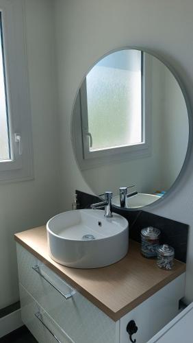 une salle de bain avec un lavabo blanc et un miroir dans l'établissement Charmant appartement proche Thales, à Cholet