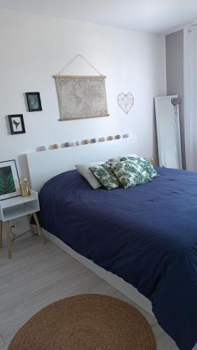 - une chambre avec un lit bleu et une table dans l'établissement Charmant appartement proche Thales, à Cholet