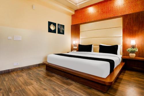 a bedroom with a large bed in a room at Super Townhouse Oak Pacify Hills in Dehradun