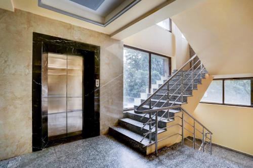 a metal staircase in a room with windows at Super Townhouse Oak Pacify Hills in Dehradun