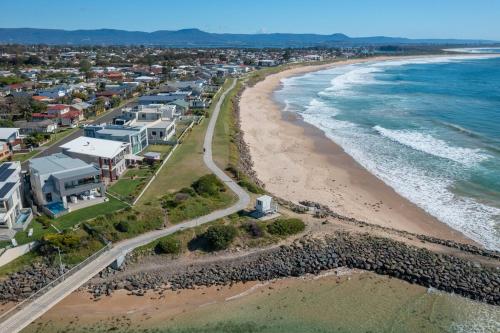 an aerial view of a beach with houses and the ocean at Salt Life By The Point On Warilla Beach in Barrack Point