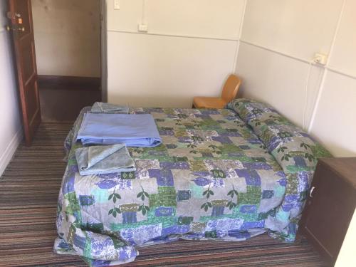 a bed with a quilt on it in a room at Royal Carrangarra Hotel in Tambo