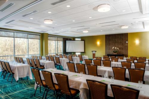 a conference room with tables and chairs and a screen at TownePlace Suites by Marriott Bellingham in Bellingham