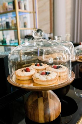 a glass display case with pastries on a table at Al Habtoor Palace Budapest, Preferred Hotels & Resorts in Budapest