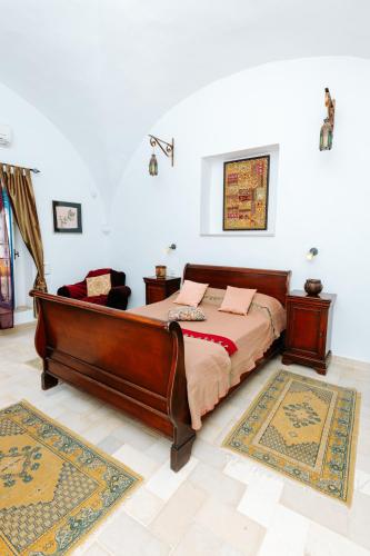 a bedroom with a bed and two rugs at Dar Jedeti Khadija in Hergla