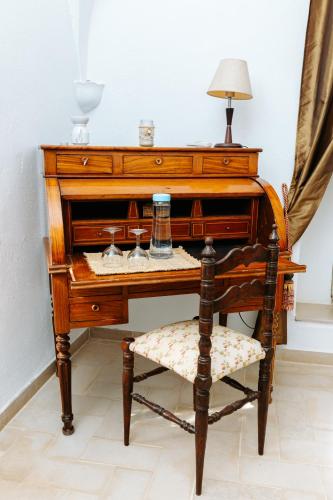 an old wooden piano with a chair and a lamp at Dar Jedeti Khadija in Hergla