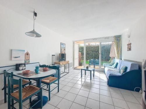 un salon avec un canapé bleu et une table dans l'établissement V-Marin 06-Vieux Boucau Studio 4 personnes en rez de jardin avec piscine, à Vieux-Boucau-les-Bains