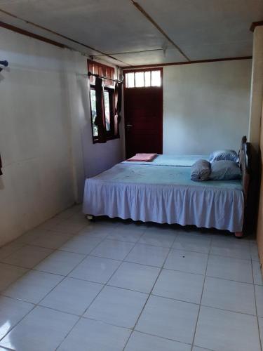 a bedroom with a bed in the corner of a room at Dian Rana Bungalow Lampuuk in Lamgire