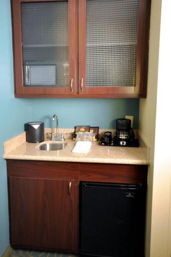 a kitchen with a sink and a stove at SpringHill Suites Galveston Island in Galveston