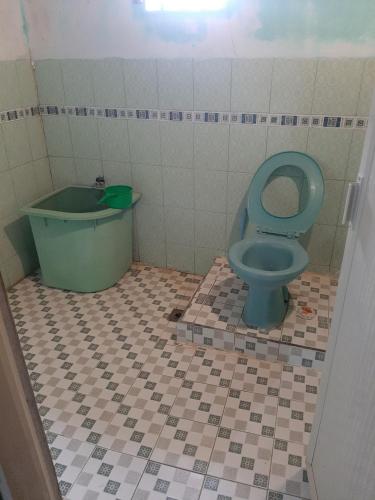 a bathroom with a blue toilet and a tub at Dian Rana Bungalow Lampuuk in Lamgire