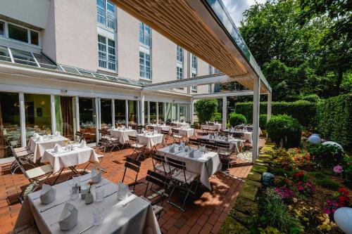 a patio with tables and chairs in front of a building at Hotel am Schlosspark in Gotha