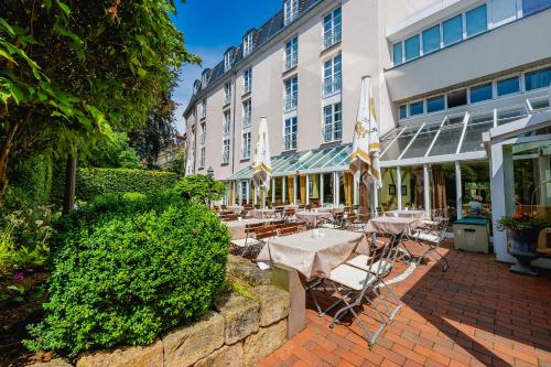 a patio with tables and chairs in front of a building at Hotel am Schlosspark in Gotha