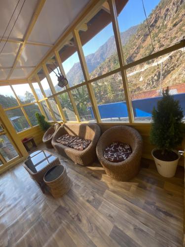 a room with a large window with chairs and a table at Loseng Farm Stay in Rupa