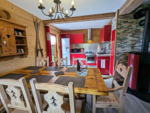 une cuisine et une salle à manger avec une table et des chaises en bois dans l'établissement Chalet Les Volets Rouges, à Cornimont