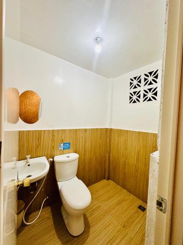 a small bathroom with a toilet and a sink at Amancio's Tourist Inn-Close to the Airport in Puerto Princesa City