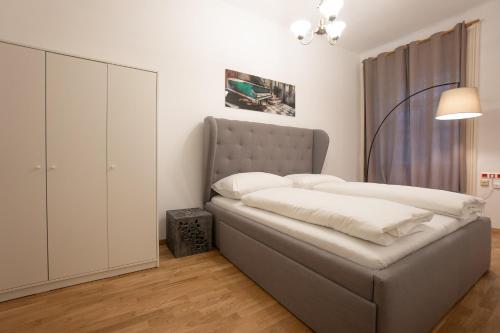Schlafzimmer mit einem Bett mit einem Kopfteil und einem Schrank in der Unterkunft Cozy 1BR apartment near Opera - 24h self check-in in Wien
