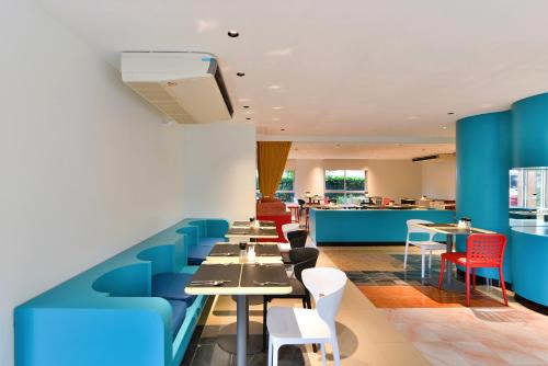 a restaurant with blue chairs and tables at The Grass Serviced Suites in Pattaya Central