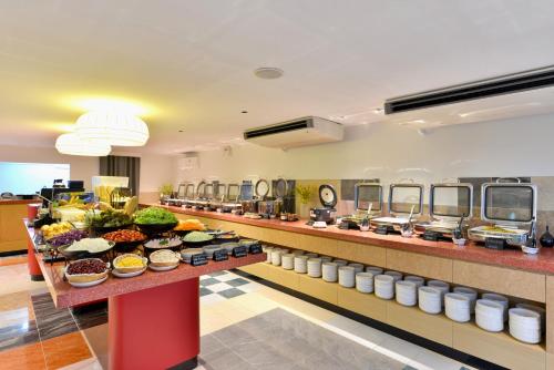 a buffet line with food in a hotel cafeteria at The Grass Serviced Suites in Pattaya Central