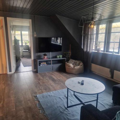 a living room with a table and a tv at Villa Fiskebäck in Västra Frölunda