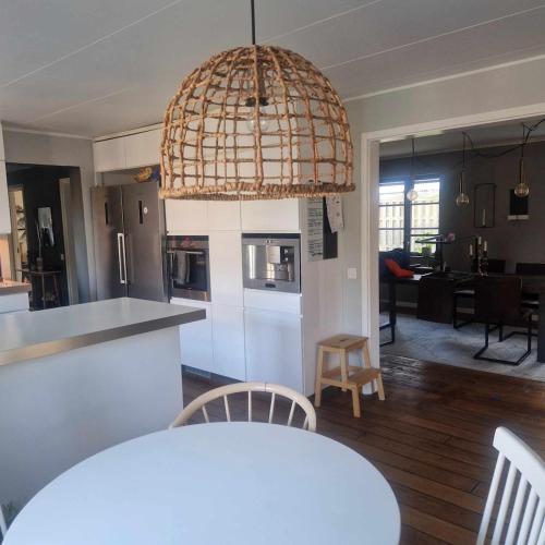 a kitchen and living room with a large chandelier at Villa Fiskebäck in Västra Frölunda