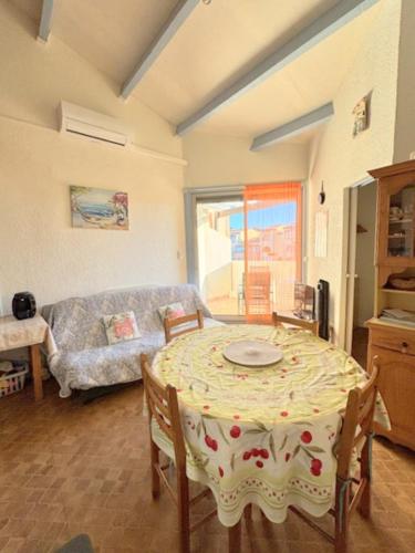 un salon avec une table et un canapé dans l'établissement Appartement 6 personnes - proche de la plage - Parking - 6FM34B1, au Barcarès