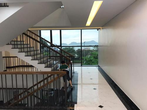 a person sitting on a staircase in a building at Gieng Ngoc Ocean moutain view Cat ba in Hai Phong