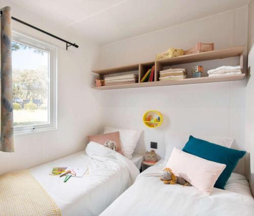 Postel nebo postele na pokoji v ubytování Mobilhome 6 personnes climatisation, TV, lave-vaisselle, 2 salle de bain, 3 chambres au camping Les Vignes à Lit-et-Mixe dans les Landes avec piscine,