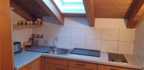 a small kitchen with a sink and a window at Alpenotel Rosenhof Ruhpolding, Wellness, Chiemgau Karte, Travelingo Bonus Programm in Ruhpolding