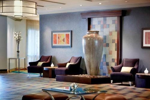 a lobby with chairs and a large vase at Costa Mesa Marriott in Costa Mesa