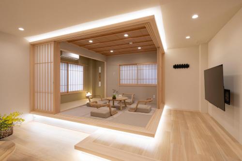 a living room with a tv and a table and chairs at Shirakabanoyado - SEIFU 白樺の宿 - 清風, 11 guests OK, ideal for groups & families, easy to Namba, USJ, Doutonbori, Osaka castle! in Osaka