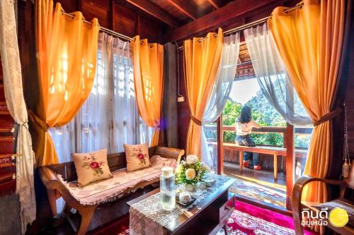 a living room with a couch and a large window at Preanhuan Homestay in Mae On