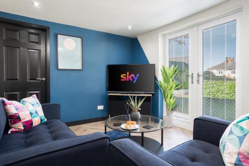 a living room with blue walls and a tv at The Lodge in Woodplumpton