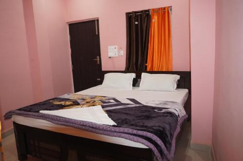 a bed in a room with pink and orange walls at Hotel Raj Residency in Sītāmarhi