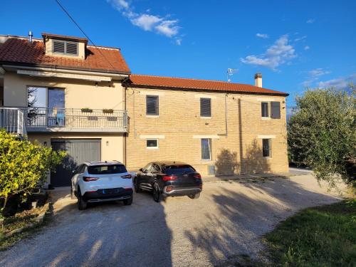 two cars parked in front of a house at Alchemilla Bed & Breakfast in Offida