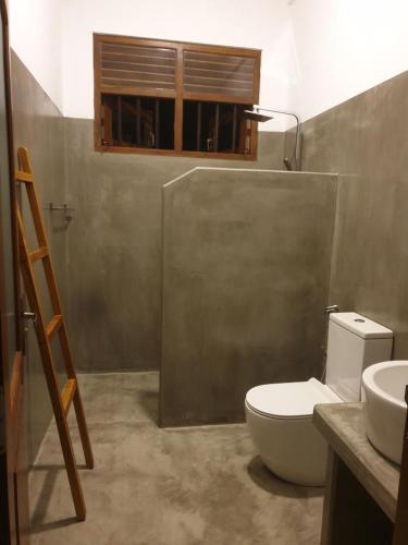 a bathroom with a toilet and a sink at CoCoSuRf House, Luxury among palms in Hikkaduwa