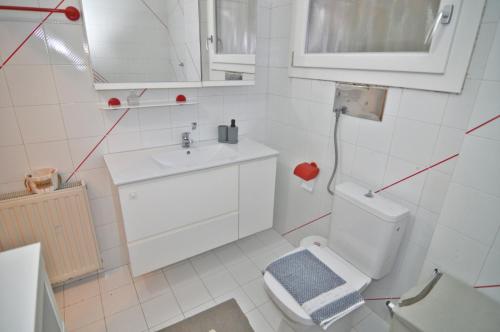 a white bathroom with a toilet and a sink at Nestoras Comfortable Stay - Private Parking in Kastoria