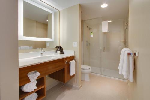 a bathroom with a sink and a shower and a toilet at SpringHill Suites by Marriott Orlando Lake Buena Vista South in Kissimmee