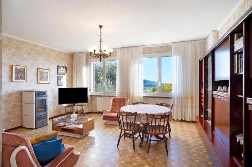 a living room with a table and chairs and a television at Villa In Collina Vista Mare in Sanremo