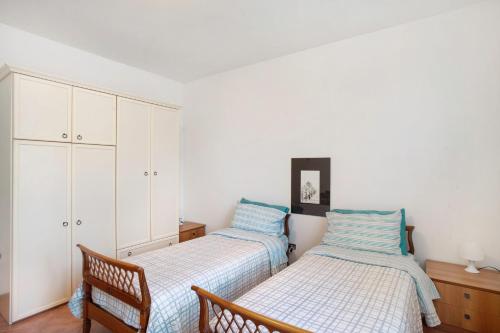 a bedroom with two beds and a chair at Villa In Collina Vista Mare in Sanremo