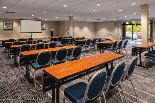 a conference room with tables and chairs and a screen at Sheraton Norfolk Waterside Hotel in Norfolk