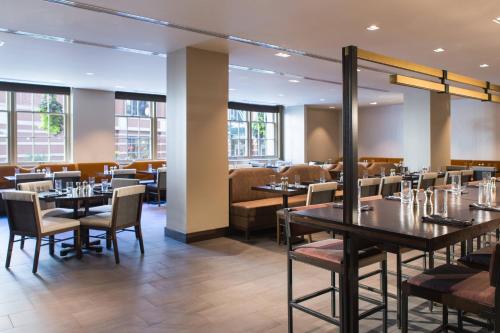 a dining room with tables and chairs and windows at Marriott St. Louis Grand in Saint Louis