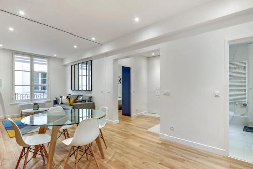 - une salle à manger et un salon avec une table et des chaises en verre dans l'établissement Flexliving - T2 - Bretagne, à Paris