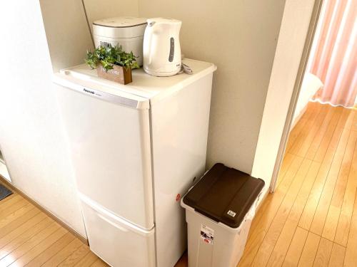 a white refrigerator with a coffee maker on top of it at mori house西が丘 in Tokyo