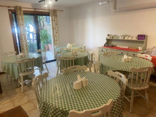 a restaurant with green and white tables and chairs at Green Grove Guest House in St Julian's