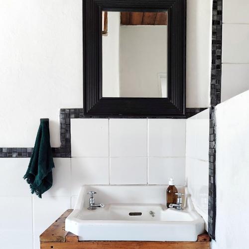 a bathroom with a white sink and a mirror at The Writer's House in Bedford